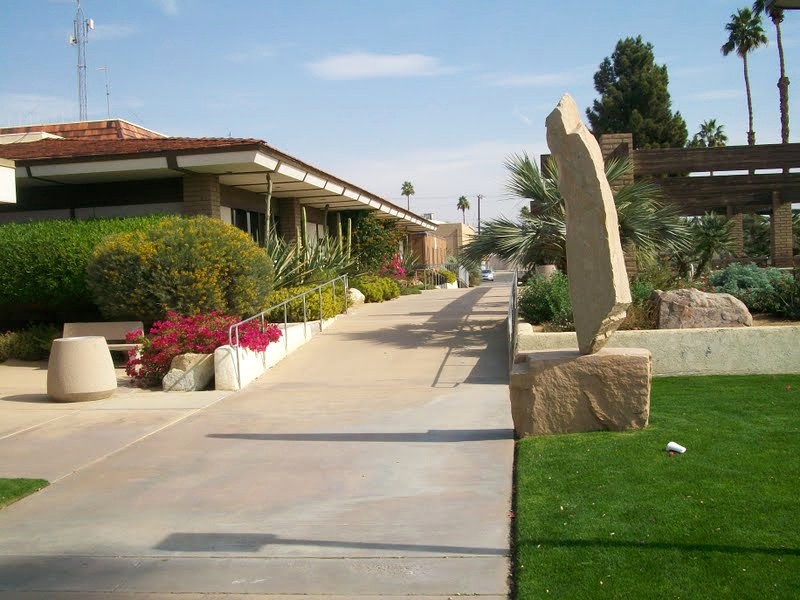 Public-facing building walkway with maintained desert planting and lawn